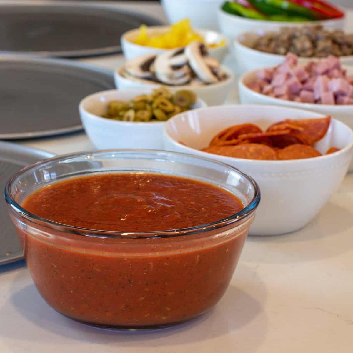 Sauce and toppings set out to make pizza.