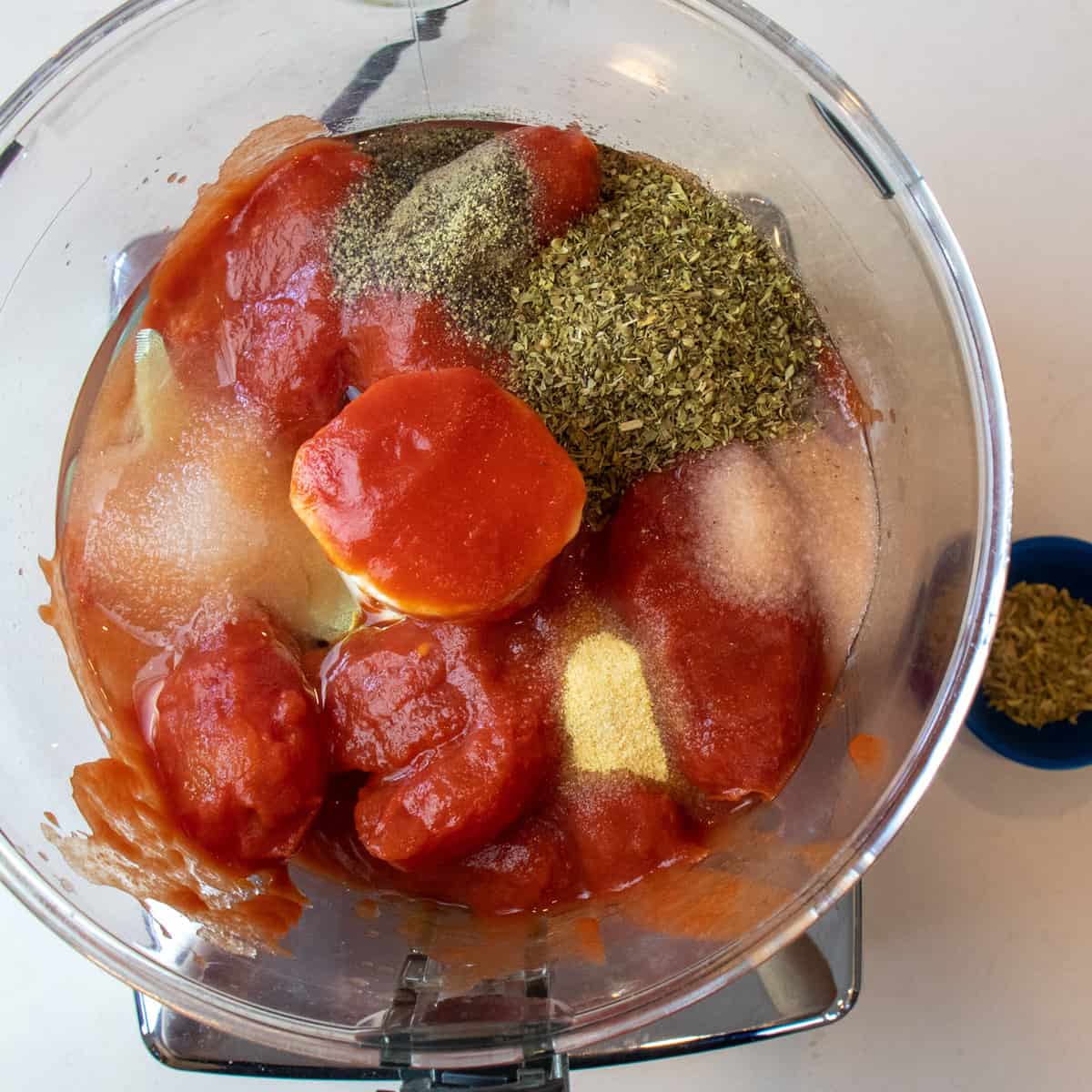 Ingredients to make homemade pizza sauce in a food processor.