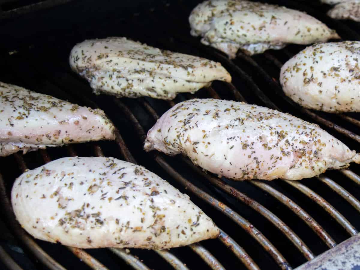 Grilling chicken breasts, ready to be flipped.