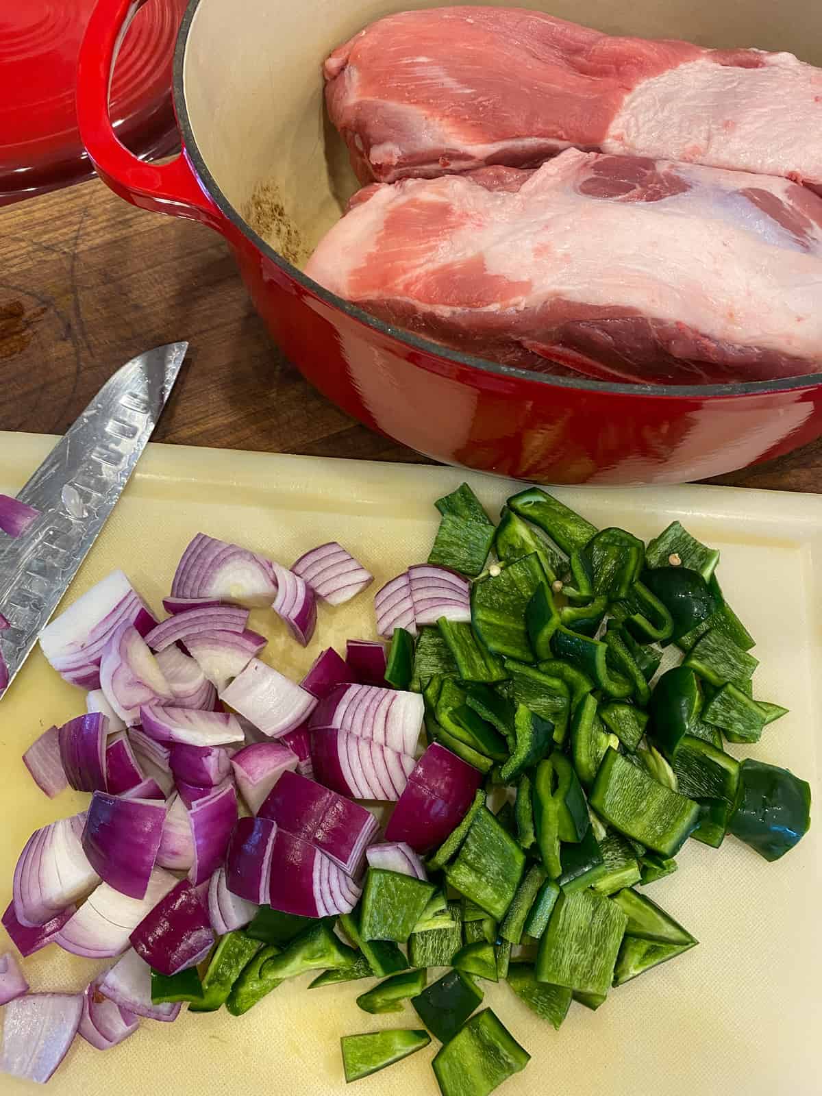 Raw pork roast with chopped onion and pepper.