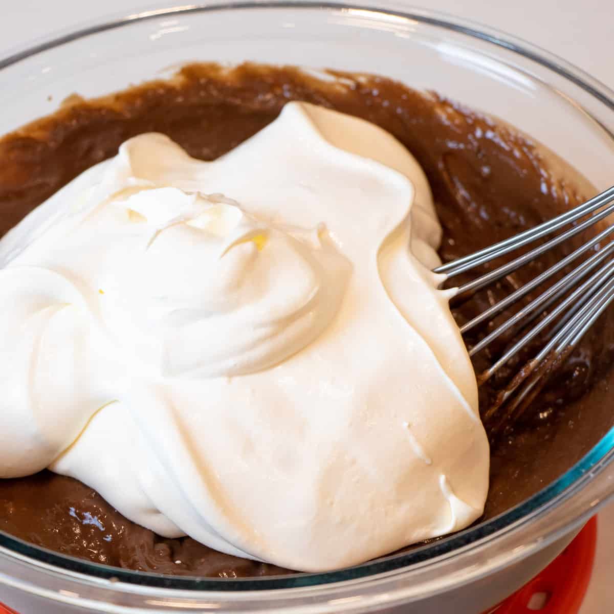 Chocolate pudding and whipped cream in a mixing bowl.