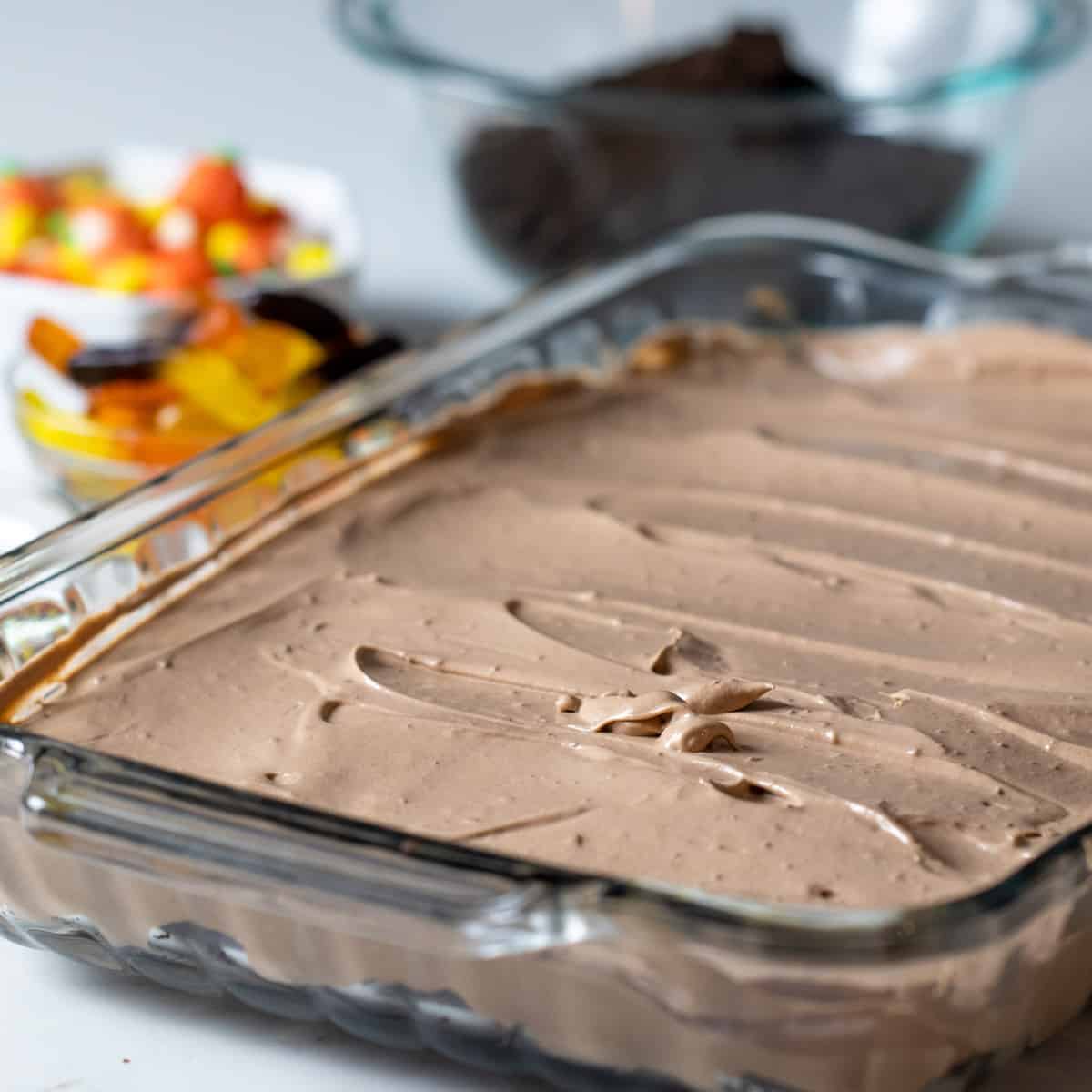 A rectangular dish with a layer of crumbled brownies and another layer of chocolate mousse.