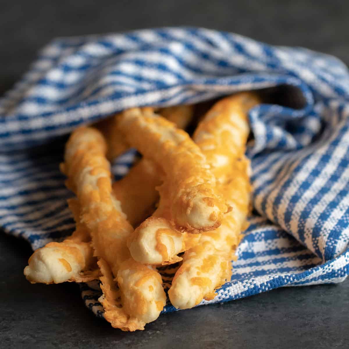 Cheese breadsticks wrapped in a kitchen towel.