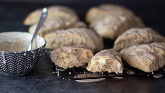 Fresh baked scones on a cooling rack with one broken in half.