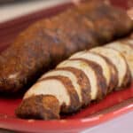 Sliced pork tenderloin on a serving platter.