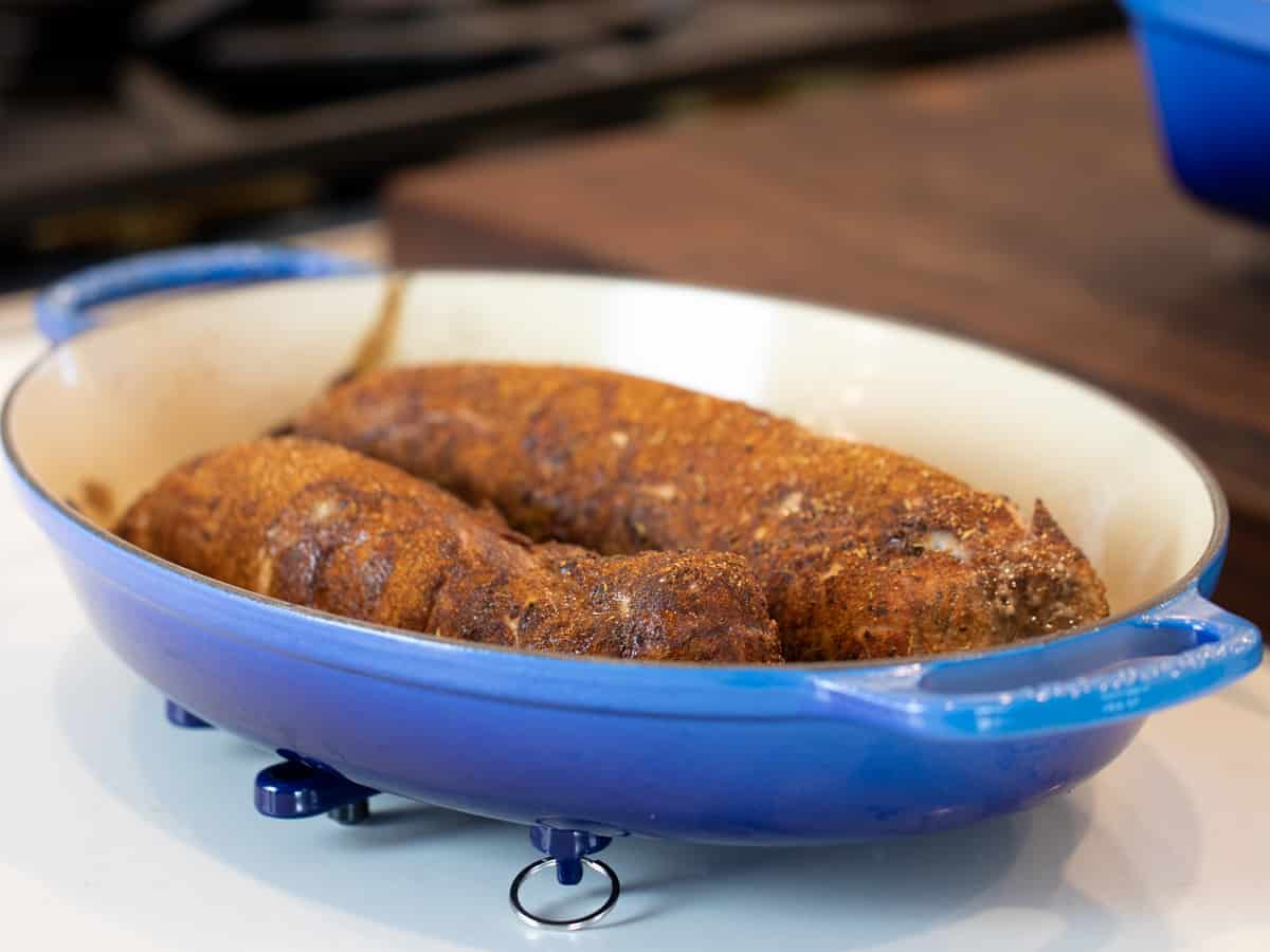 Two baked tenderloins in a roasting dish.