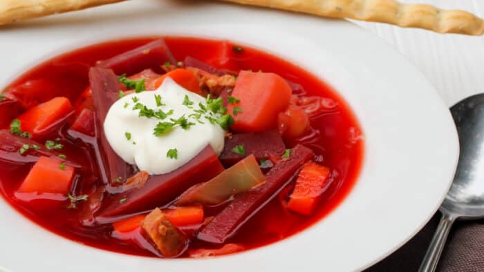 Close up picture of a bowl of soup with a dollop of sour cream.