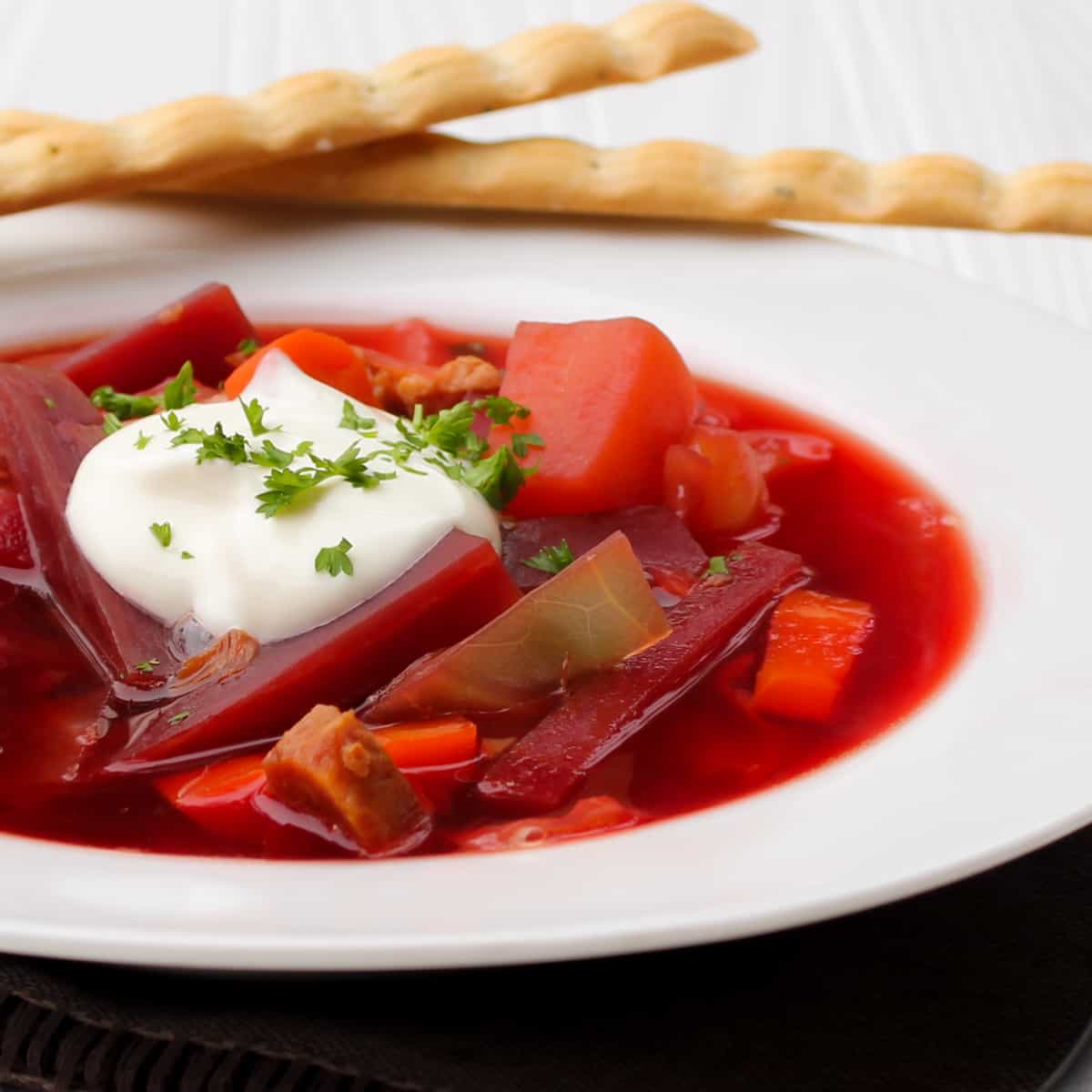 A close up picture of a bowl of borscht.