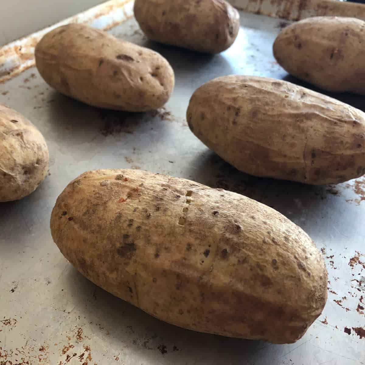 Russet potatoes on a baking sheet.