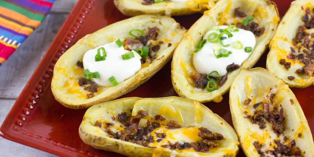 A plate of baked potato skins with a dollop of sour cream.