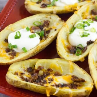 A plate of baked potato skins with a dollop of sour cream.