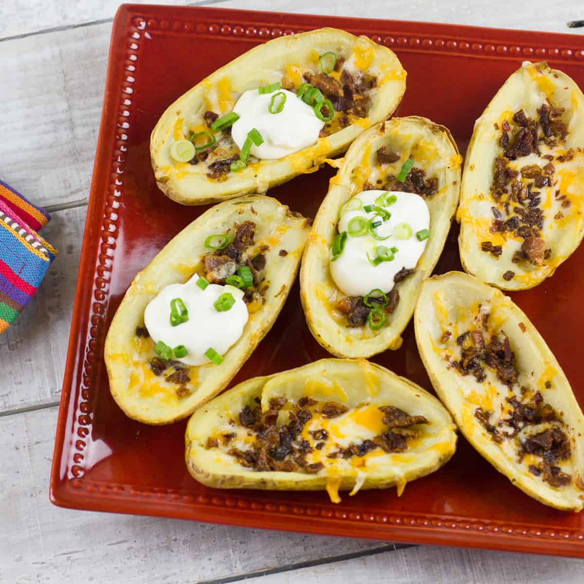 A plated of baked potato with bacon and cheddar cheese.