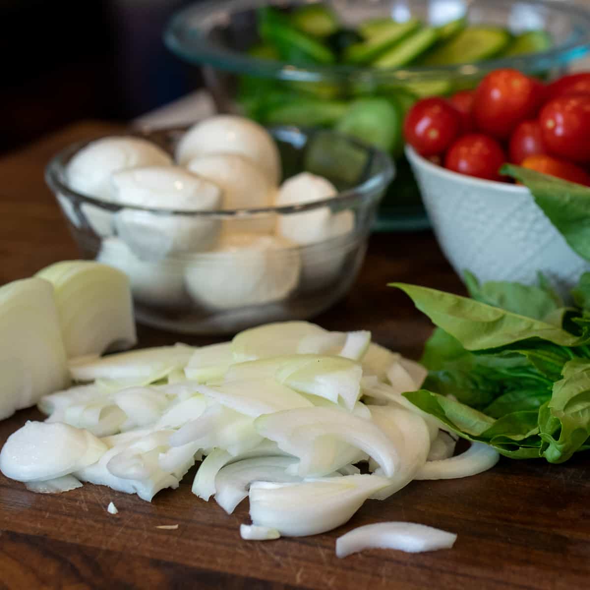 Sweet onions sliced on a cutting board.