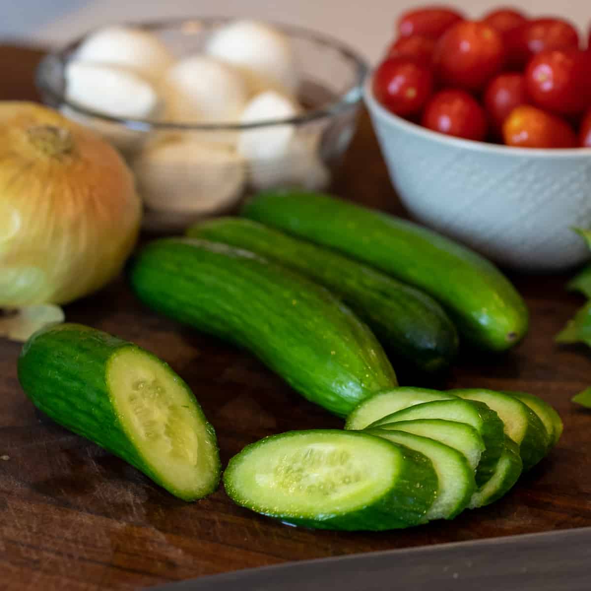 Mini cucumbers sliced thinly on an angle.