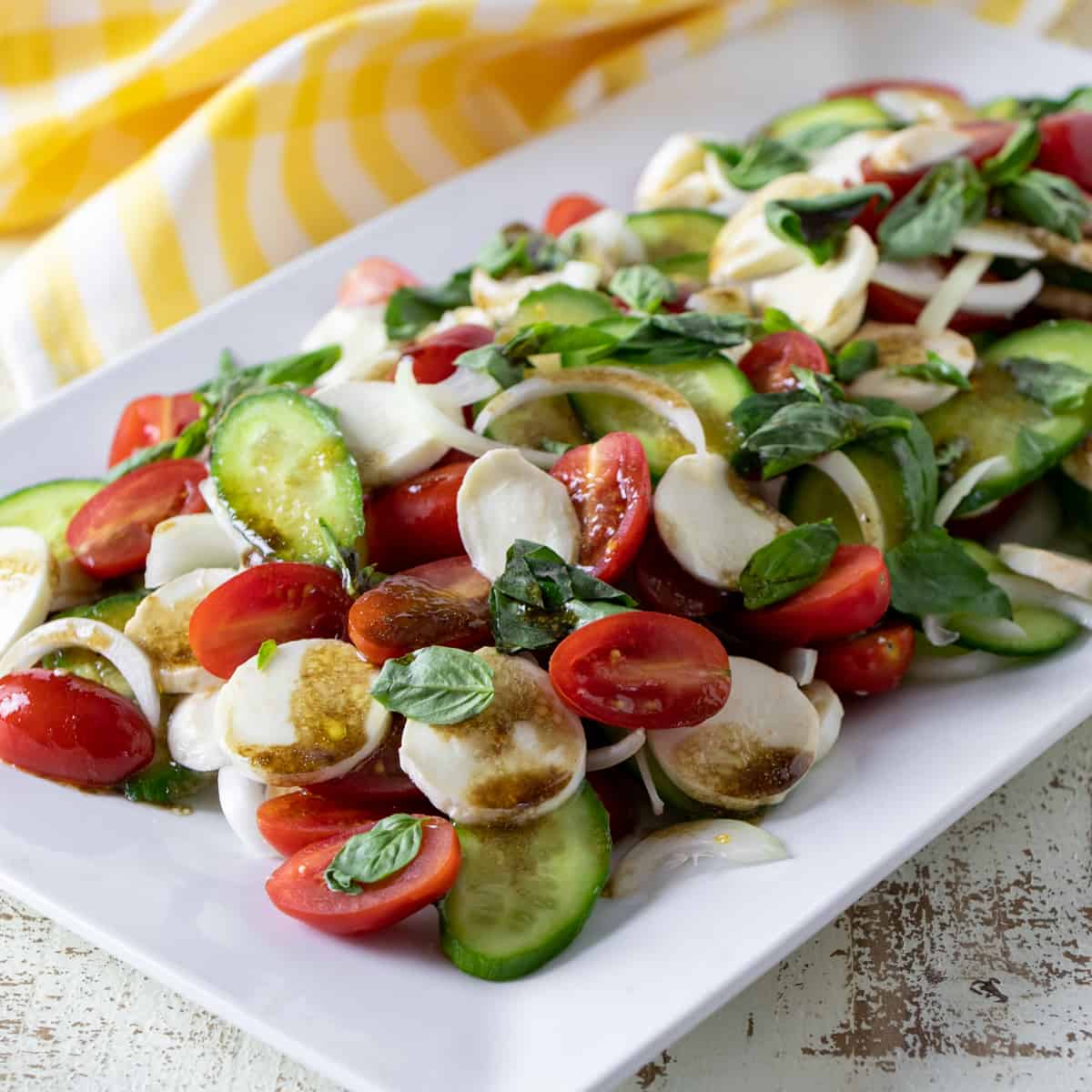 A plate of salad with balsamic dressing drizzled on top.