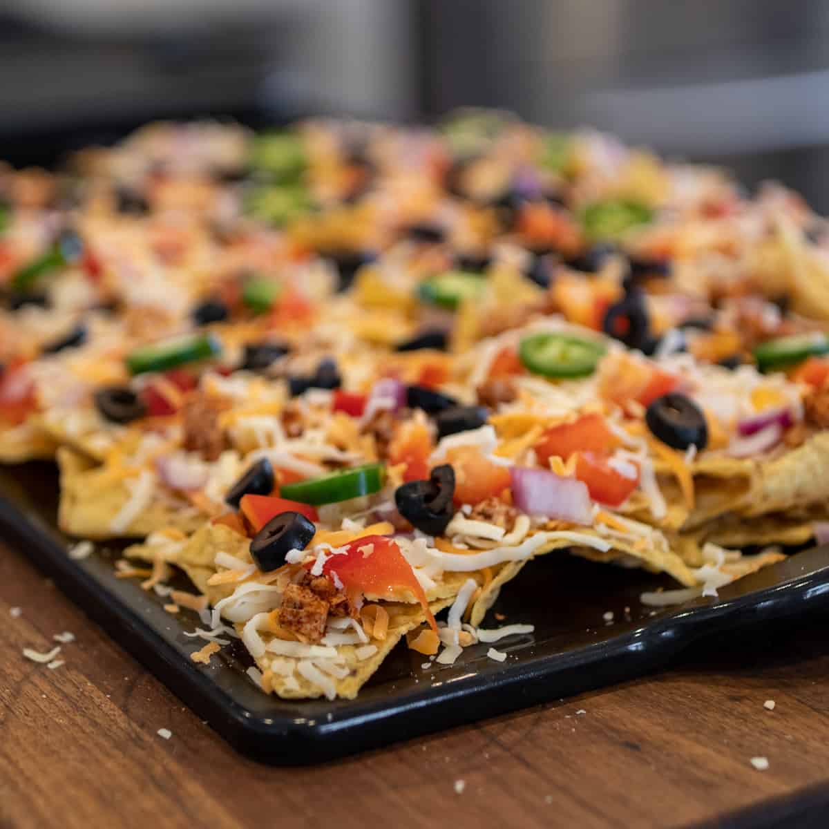 A close up of a tray of nachos that have not gone into the oven.