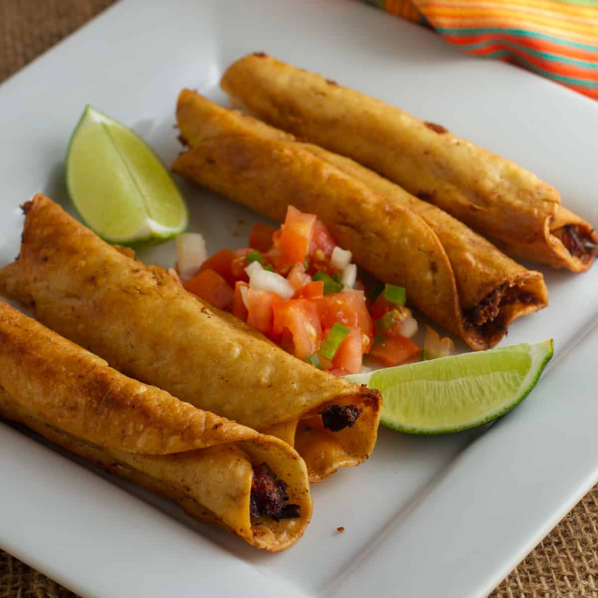 A plate of chicken flautas with pico de Gallo.