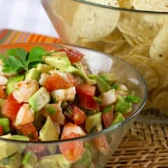A bowl of diced shrimp, tomatoes and avocados.