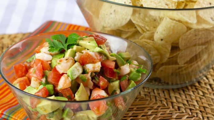 A bowl of diced shrimp, tomatoes and avocados.