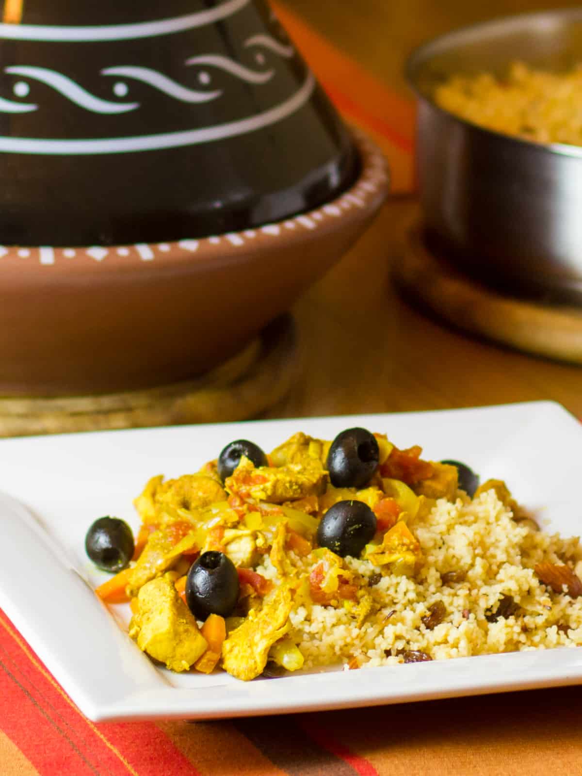 Tagine and couscous on a white square plate.