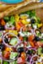 An overhead picture of salad in a wooden serving bowl.