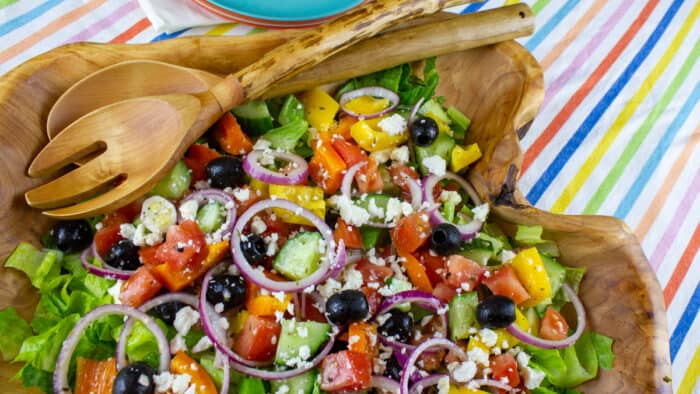 An overhead picture of salad in a wooden serving bowl.