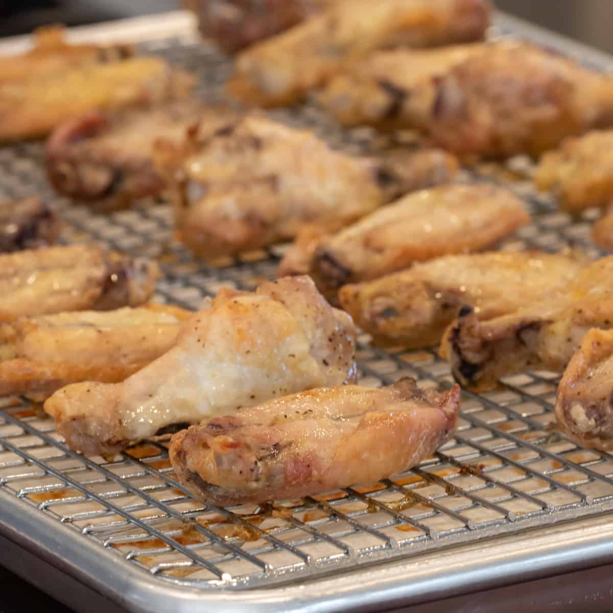 Crispy chicken wings on a baking sheet.