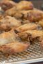 Baked chicken wings on a baking sheet with a rack.