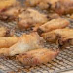 Cooked chicken wings on a baking sheet.