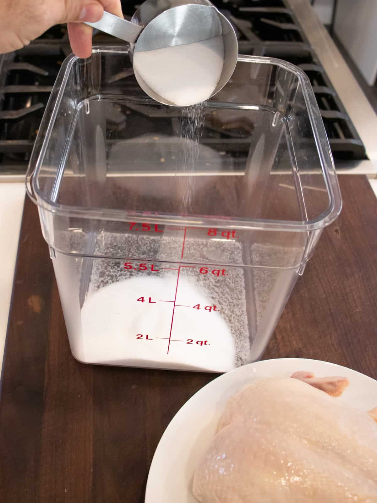 Dumping salt into a clear rectangular container.