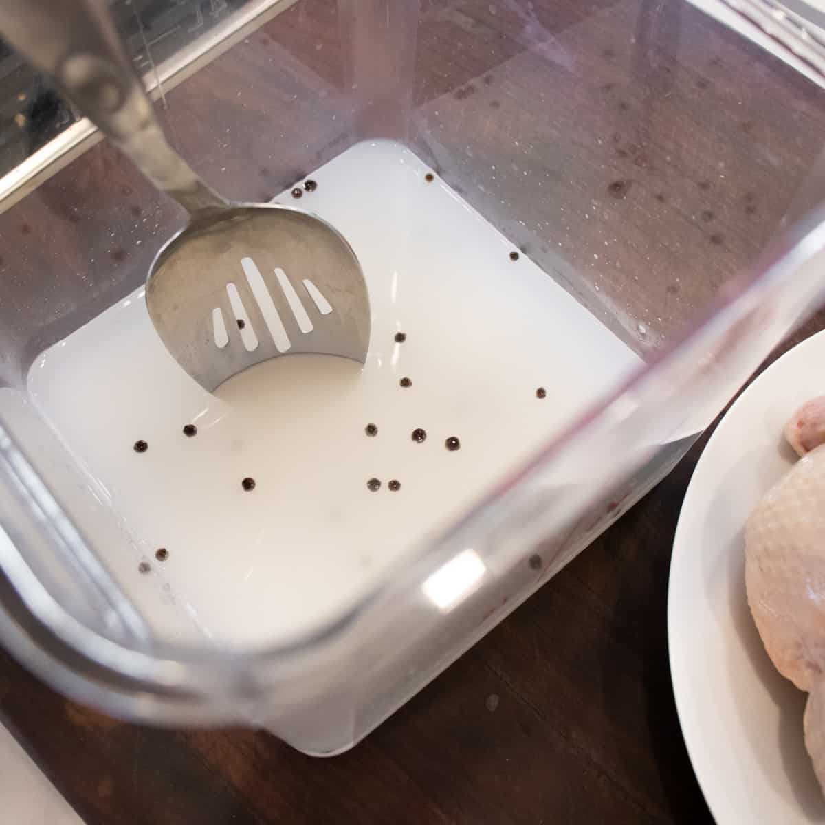 Using a metal spoon to stir and dissolve the salt in the water.