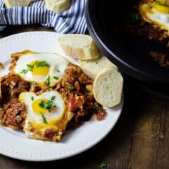 Cooked eggs on a bed of stewed tomatoes.