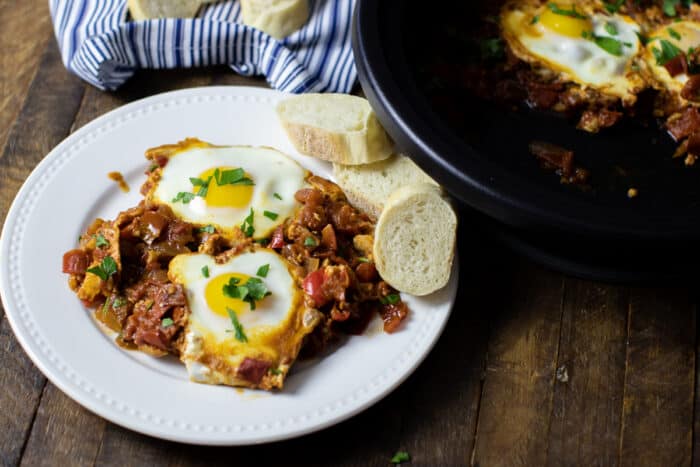 Cooked eggs on a bed of stewed tomatoes.