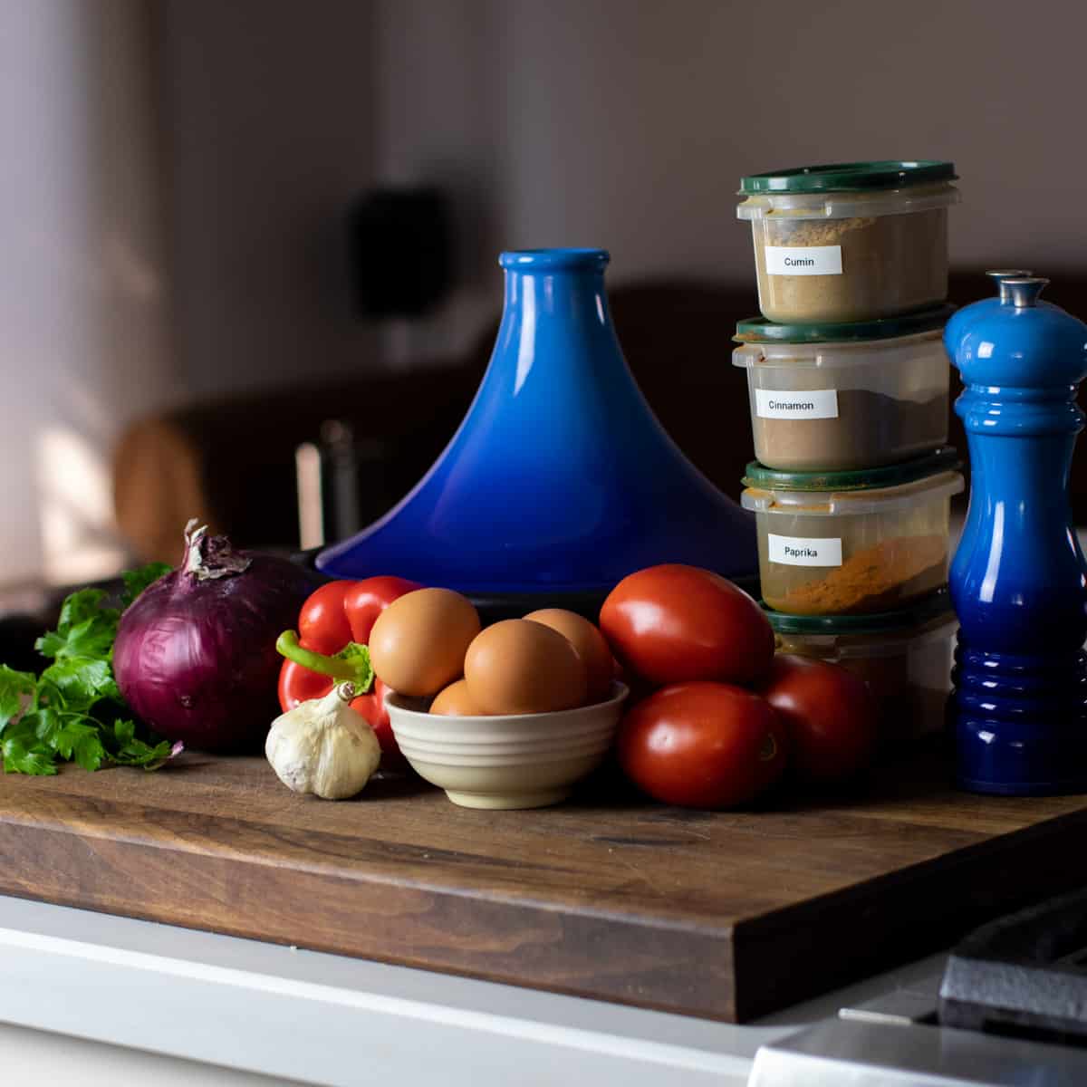 Ingredients for shaksuka gathered on a cutting board.