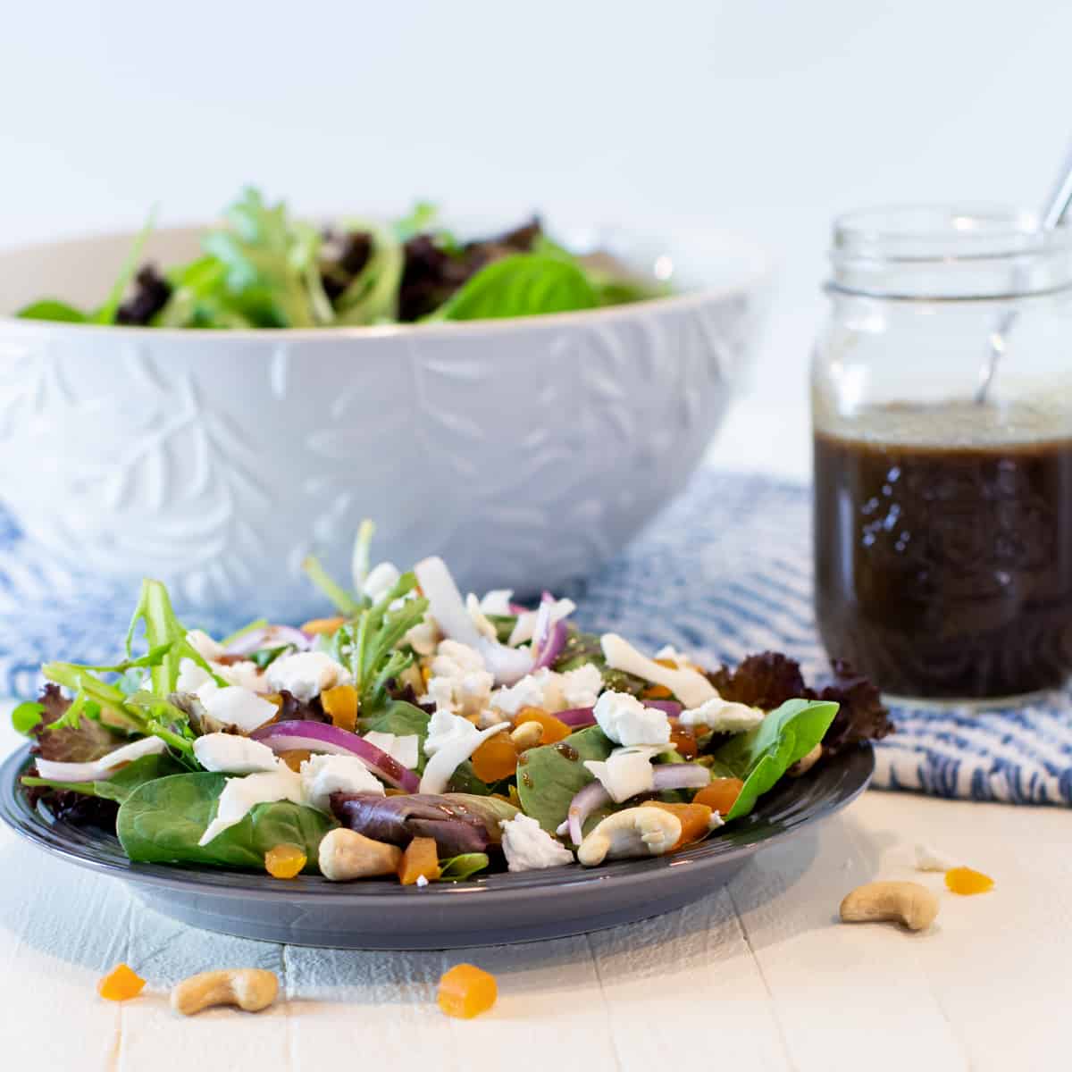 Spinach salad in a small plate and a large serving bowl.