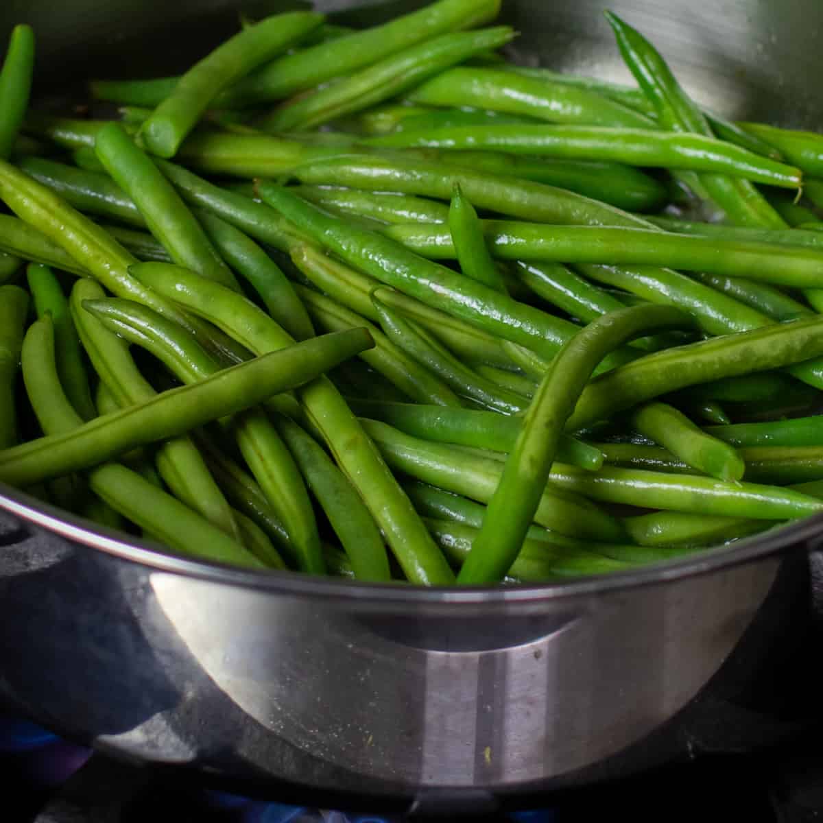 Raw green beans in a frying pan.