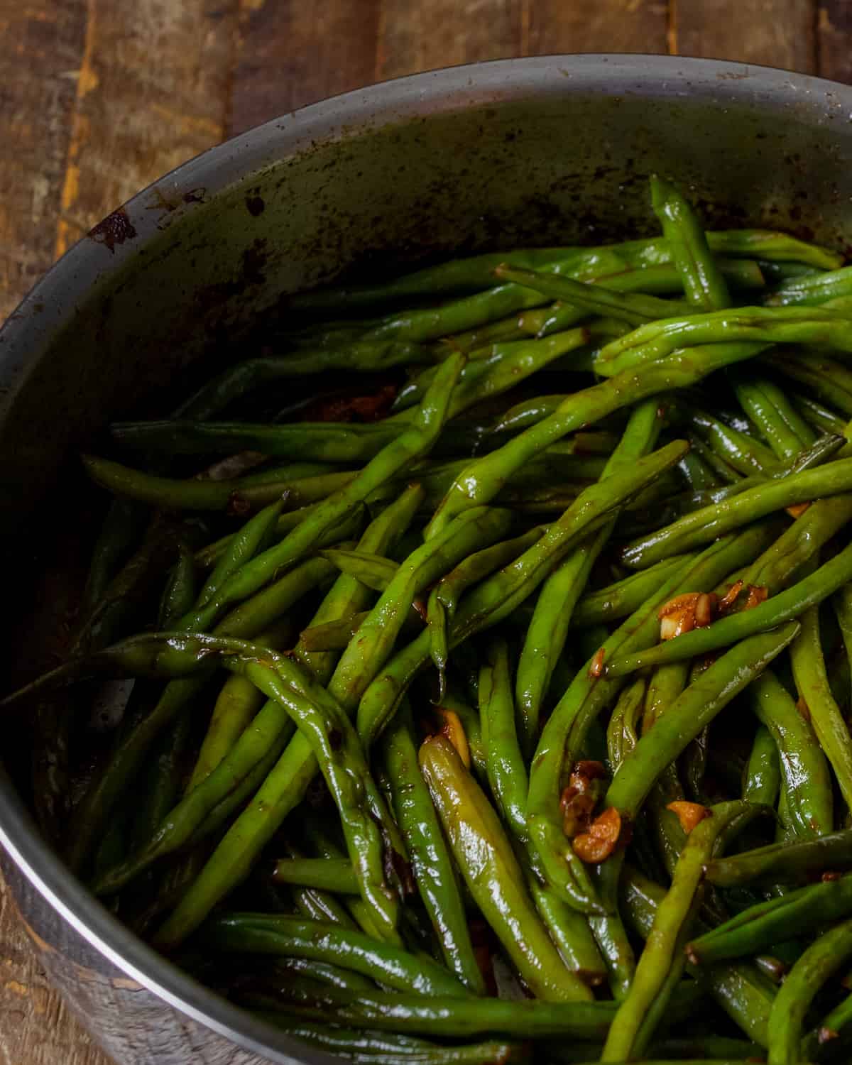 Cooked green beans with sriracha sauce.