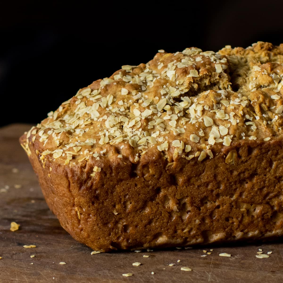 A freshly baked loaf of bread with oats sprinkled on top.