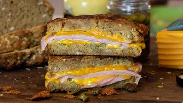 Grilled ham and cheese sandwich cut in half and stacked.