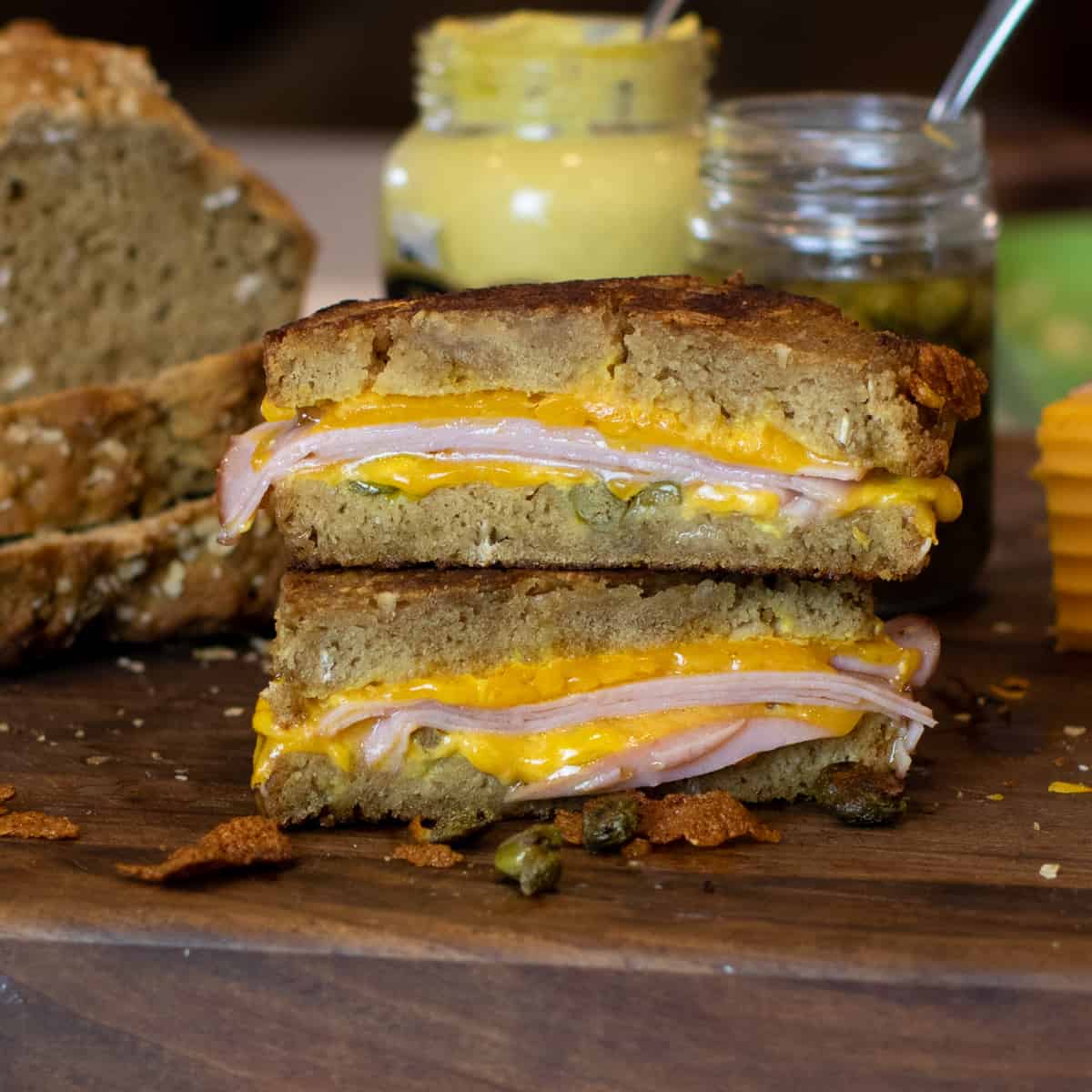Grilled ham and cheese sandwich on a cutting board.