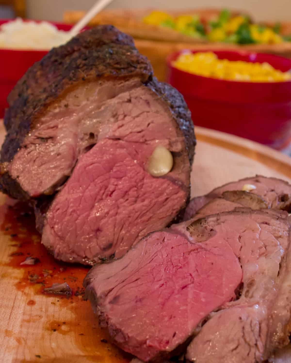 Medium rare roast beef sliced on a cutting board.