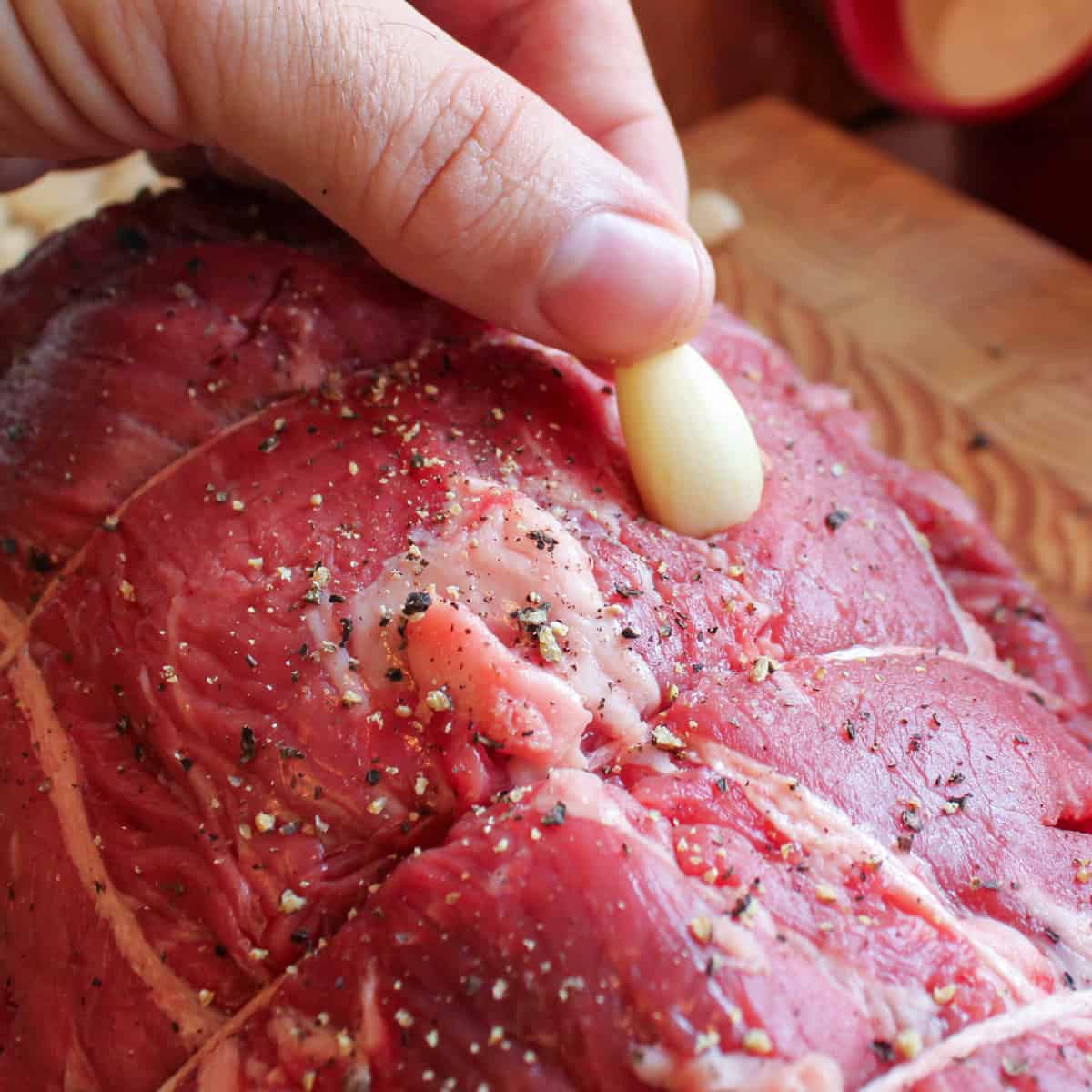 Sticking garlic into the roast.