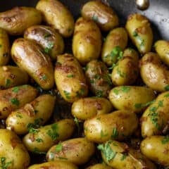Mini potatoes cooked in a large skillet.