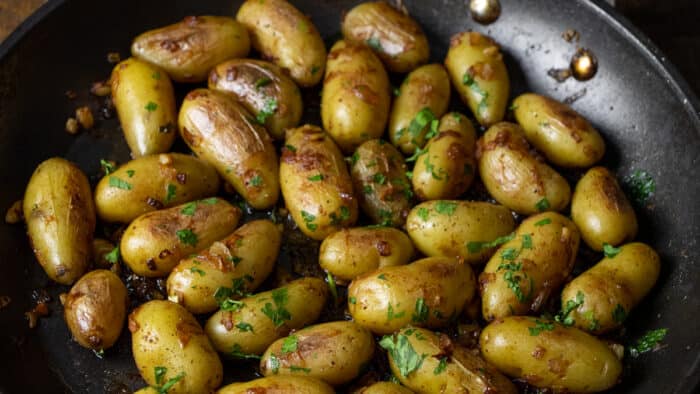 Mini potatoes cooked in a large skillet.