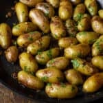 Overhead pictures of cooked fingerling potatoes in a large skillet.