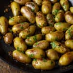 Overhead pictures of cooked fingerling potatoes in a large skillet.