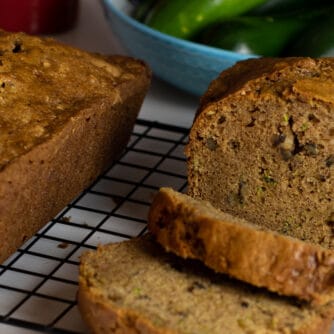 Loaves of fresh baked zucchini bread on a cooling rack.