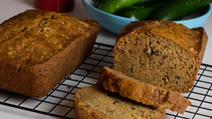 Loaves of fresh baked zucchini bread on a cooling rack.