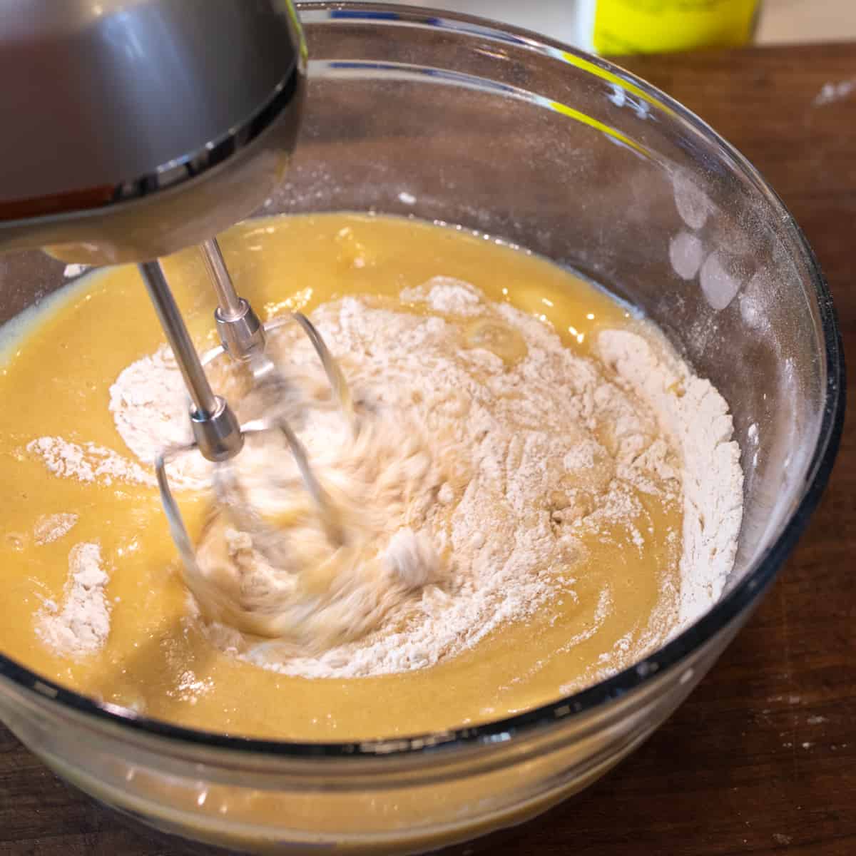 An electric mixer beating the wet and dry ingredients together.