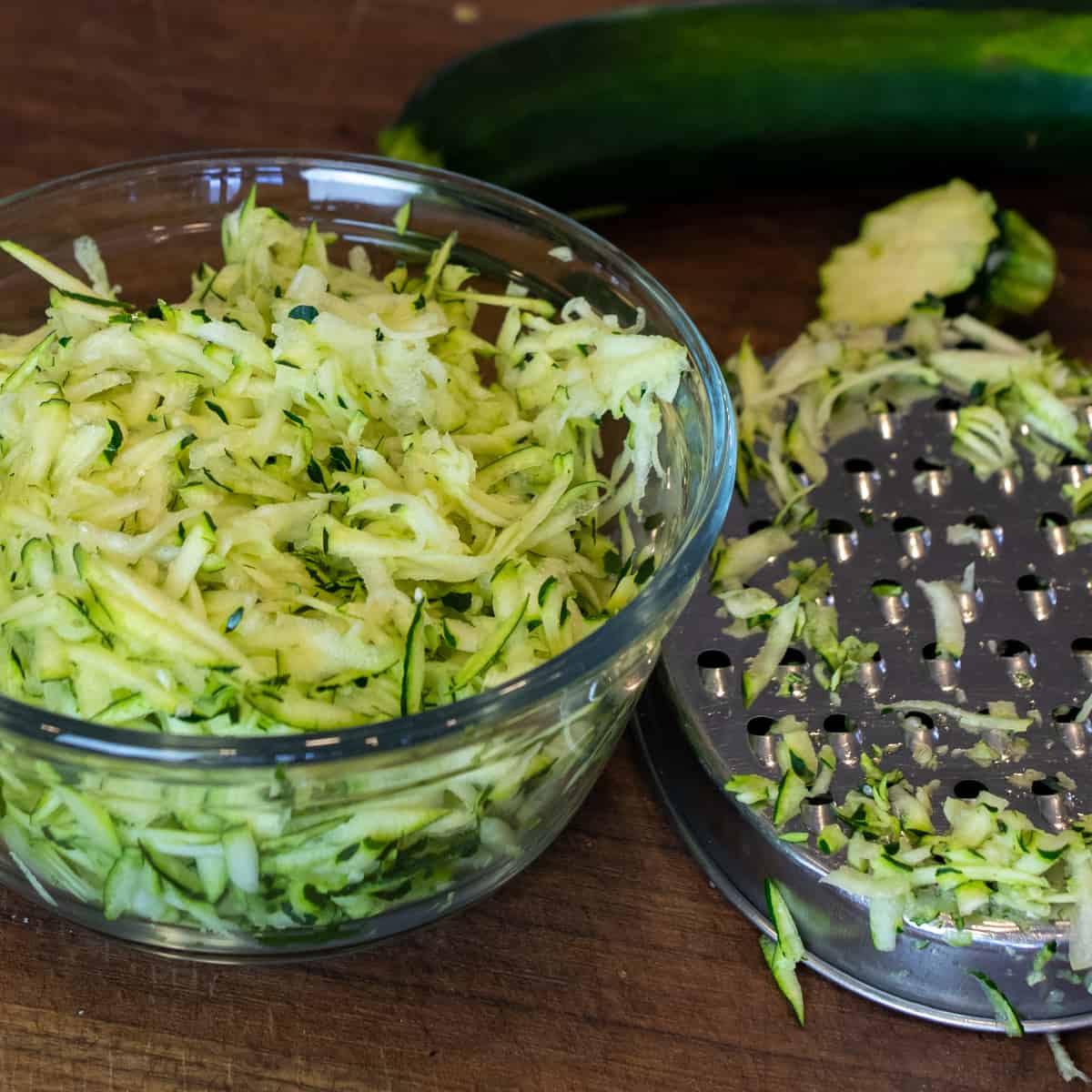 A glass bowl filled with grated zucchini.